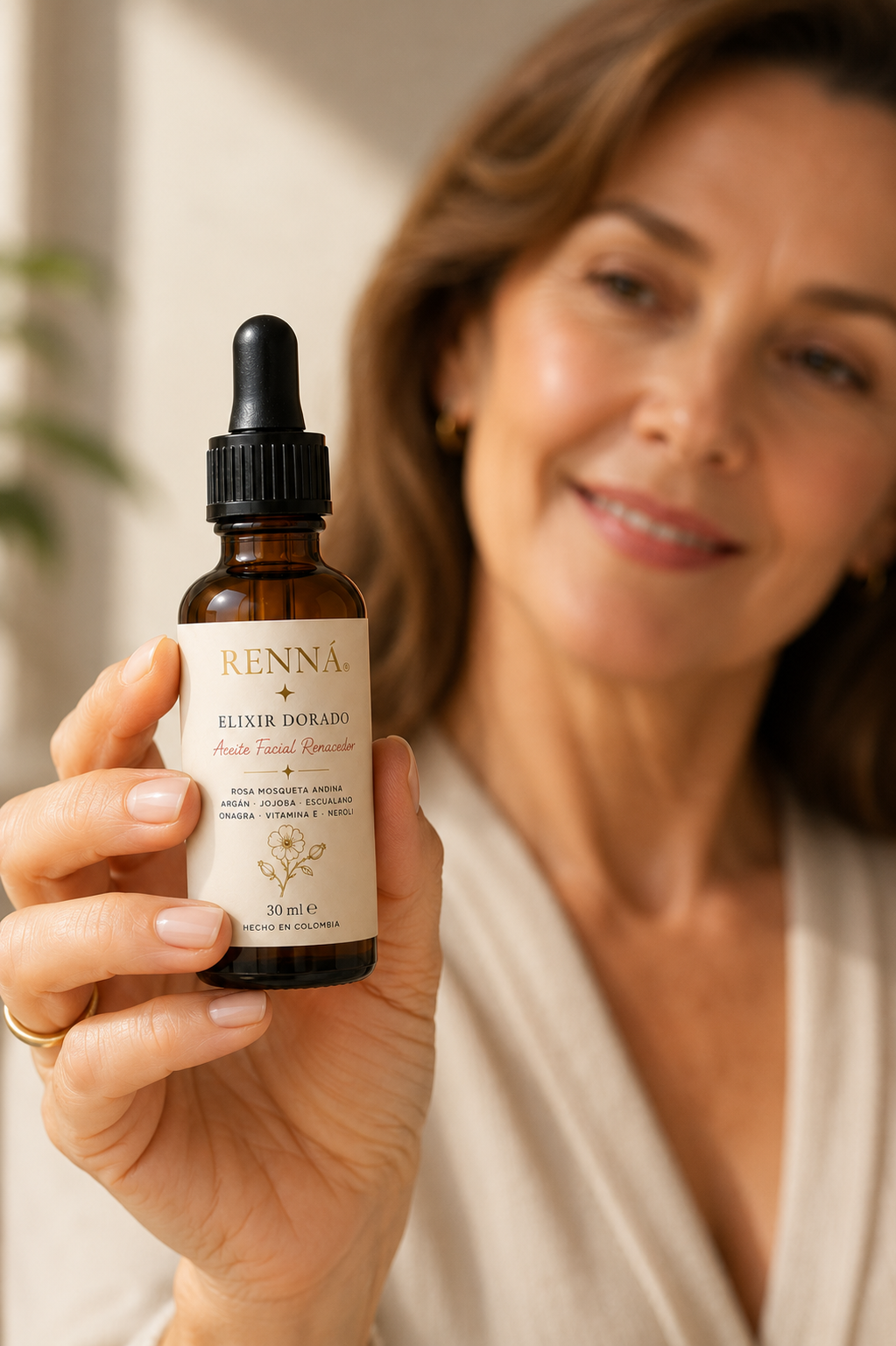 Mujer 50 años sosteniendo aceite facial RENNÁ